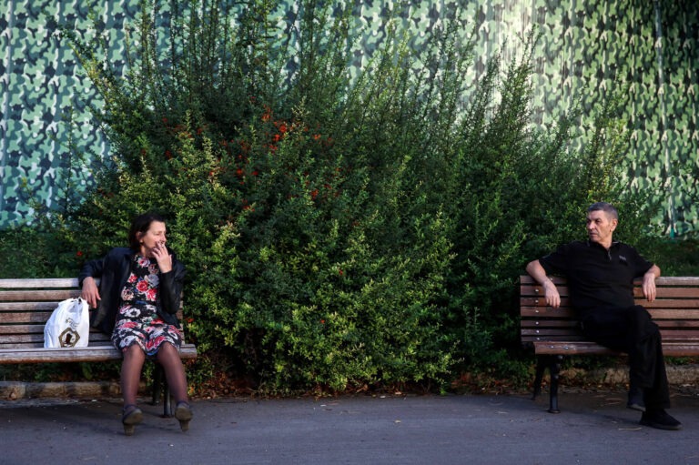 ljudo sede na dve odvojene klupe