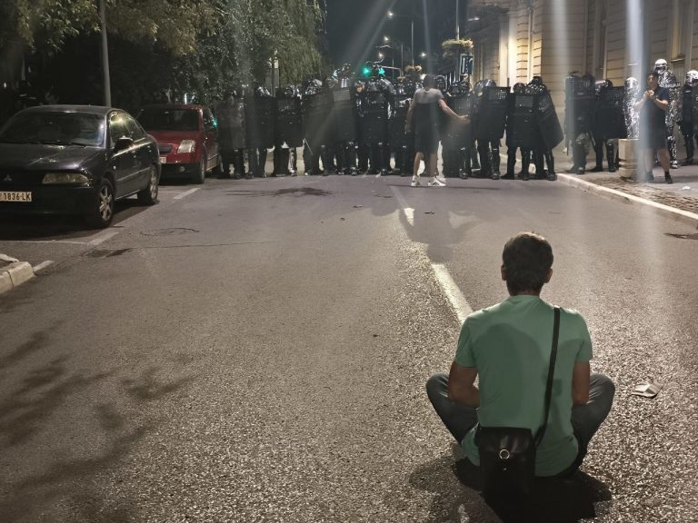 demonstrant pred kordonom policije